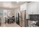 Modern kitchen and dining area with stainless steel appliances and stylish light fixture at 3668 E Derringer Way, Gilbert, AZ 85297