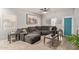 Inviting living room featuring a plush gray sectional, wood-look tile floors, and a view of the backyard at 3668 E Derringer Way, Gilbert, AZ 85297