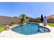 Gorgeous backyard pool with rock features, umbrellas, and well manicured plants at 3668 E Derringer Way, Gilbert, AZ 85297