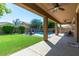 Covered patio overlooking backyard featuring a swimming pool with water feature, lush lawn and mature trees at 3693 E Sparrow Pl, Chandler, AZ 85286