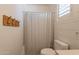 Clean bathroom features a toilet, shower with curtain, and neutral color palette at 3931 E Weather Vane Rd, Gilbert, AZ 85296