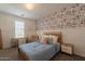 Comfortable bedroom with stylish wallpaper, a desk, and natural light at 3931 E Weather Vane Rd, Gilbert, AZ 85296