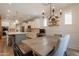 Open-concept kitchen featuring white cabinets, stainless steel appliances, and an adjacent dining area at 3931 E Weather Vane Rd, Gilbert, AZ 85296
