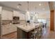 Bright kitchen with island seating, white cabinetry, and seamless transition to dining area at 3931 E Weather Vane Rd, Gilbert, AZ 85296
