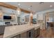 Open kitchen with island sink seamlessly connects to the fireplace and adjacent living room areas at 3931 E Weather Vane Rd, Gilbert, AZ 85296