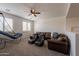 Spacious living room features a brown leather sofa, a ceiling fan and a basketball hoop at 3931 E Weather Vane Rd, Gilbert, AZ 85296