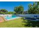 A backyard featuring a pool, artificial grass, a basketball hoop and a trampoline at 3931 E Weather Vane Rd, Gilbert, AZ 85296