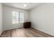 Empty bedroom featuring wood-look floors, a ceiling fan, and a window with blinds at 423 W Century Ct, Gilbert, AZ 85233