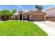 Charming single-story home featuring a lush green lawn and a two-car garage at 423 W Century Ct, Gilbert, AZ 85233