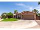 Attractive one-story home featuring a lush lawn, circular driveway and two-car garage at 423 W Century Ct, Gilbert, AZ 85233