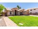 Charming home boasts a lush green lawn, desert landscaping, and a welcoming facade at 423 W Century Ct, Gilbert, AZ 85233