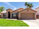 Single-story home with a desert landscape, two-car garage, and shaded front entry at 423 W Century Ct, Gilbert, AZ 85233