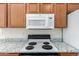 Kitchen range and microwave featuring wood cabinets and speckled countertops at 423 W Century Ct, Gilbert, AZ 85233