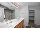 Bathroom featuring a double vanity, large mirror, and access to a shower and walk-in closet at 4530 E White Feather Ln, Cave Creek, AZ 85331
