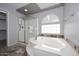 Bathroom featuring a large soaking tub, glass shower, and a privacy window at 4530 E White Feather Ln, Cave Creek, AZ 85331