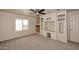 Spacious carpeted bedroom featuring a ceiling fan, built-in desk, and white door at 4530 E White Feather Ln, Cave Creek, AZ 85331