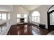 Spacious living room with rich wood floors, fireplace, large arched window, and black decorative door at 4530 E White Feather Ln, Cave Creek, AZ 85331