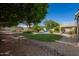 Serene backyard featuring lush grass, manicured landscaping, and a view of the inviting pool area at 4648 W Misty Willow Ln, Glendale, AZ 85310