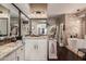 Bathroom with double granite countertop sinks, wall mirror, and modern soaking tub at 4648 W Misty Willow Ln, Glendale, AZ 85310