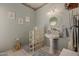 Chic bathroom offers modern fixtures, pedestal sink, glass block detail, and soft blue walls at 4648 W Misty Willow Ln, Glendale, AZ 85310