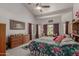 Spacious bedroom with vaulted ceilings, ceiling fan, large bed, dresser, and outdoor views at 4648 W Misty Willow Ln, Glendale, AZ 85310