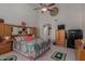 Bedroom with ceiling fan, dresser, large bed, TV, and closet access at 4648 W Misty Willow Ln, Glendale, AZ 85310