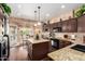 Well-appointed kitchen featuring granite counters, brown cabinets, an island and lots of natural light at 4648 W Misty Willow Ln, Glendale, AZ 85310
