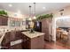 Charming kitchen with granite counters, island, pendant lights, and brown cabinets providing ample storage at 4648 W Misty Willow Ln, Glendale, AZ 85310