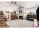 Bright living room with a fireplace, piano, and floral-patterned sofa and chairs at 4648 W Misty Willow Ln, Glendale, AZ 85310