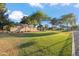 Well maintained front yard featuring green grass and mature shade trees at 4725 E Brown Rd # 13, Mesa, AZ 85205