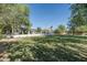 Lush backyard with mature trees, green lawn, and a charming patio area for relaxation and entertaining at 5112 N 41St St, Phoenix, AZ 85018