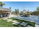 Expansive backyard featuring a pool with waterfall, manicured lawn, and stylish patio area for entertaining at 5112 N 41St St, Phoenix, AZ 85018