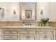 Bathroom vanity with a neutral stone countertop, double sconces, stylish faucet and a decorative mirror at 5112 N 41St St, Phoenix, AZ 85018