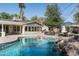 An inviting pool features a rock waterfall, paired with outdoor seating and dining at 5112 N 41St St, Phoenix, AZ 85018