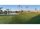 Picturesque view of a golf course and lake with palm trees, enhancing the property's appeal at 520 S Sand Verbena Way, Mesa, AZ 85208