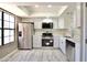 Modern kitchen with stainless steel appliances, quartz countertops, white cabinets, and ample natural light from the window at 520 S Sand Verbena Way, Mesa, AZ 85208