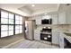 Modern kitchen with stainless steel appliances, quartz countertops, white cabinets, and natural light from a large window at 520 S Sand Verbena Way, Mesa, AZ 85208