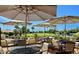 Enjoy outdoor seating with umbrellas overlooking lush green spaces, perfect for relaxing or entertaining guests at 520 S Sand Verbena Way, Mesa, AZ 85208