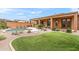 Outdoor living featuring a pool, green grass, desert landscaping, and covered patio at 5650 E Ocupado Dr, Cave Creek, AZ 85331