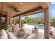 Inviting covered patio featuring comfortable seating and a view of the sparkling pool and lush landscaping at 5650 E Ocupado Dr, Cave Creek, AZ 85331