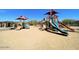 Community playground featuring slides, climbing structures, and shaded areas on a sandy ground at 5650 E Ocupado Dr, Cave Creek, AZ 85331