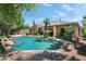 The backyard features a beautiful pool with rock features, landscaping, and desert surroundings at 5758 E Fox St, Mesa, AZ 85205