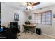 This bedroom offers a comfortable workspace with a ceiling fan, natural light, and a neutral color palette at 5758 E Fox St, Mesa, AZ 85205