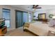 Bedroom with neutral walls and carpet, dresser, TV, ceiling fan, and sliding glass door to the outside at 5758 E Fox St, Mesa, AZ 85205