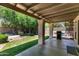 Covered patio looking out to a grassy lawn with grill and patio furniture ready for entertaining at 5758 E Fox St, Mesa, AZ 85205