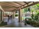 The covered patio offers a backyard view of tropical landscaping and a backyard pool at 5758 E Fox St, Mesa, AZ 85205