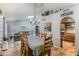 Well-lit dining room with a classic chandelier, seating for eight, and an open view of the living area at 5758 E Fox St, Mesa, AZ 85205