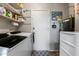 Functional laundry room featuring shelving, white appliances, and a convenient water heater at 5758 E Fox St, Mesa, AZ 85205