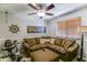 Comfortable living room featuring a large brown sectional, ceiling fan, and a workout bike at 5758 E Fox St, Mesa, AZ 85205