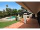 Covered backyard patio leads to a pool with a black metal fence. Lots of trees at 6525 N 3Rd St, Phoenix, AZ 85012